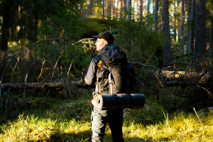 man in woods carrying tactical backpack