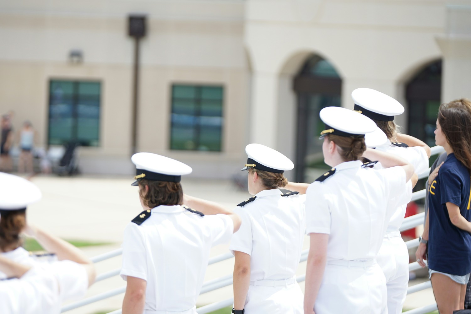 five Naval recruits in uniform saluting