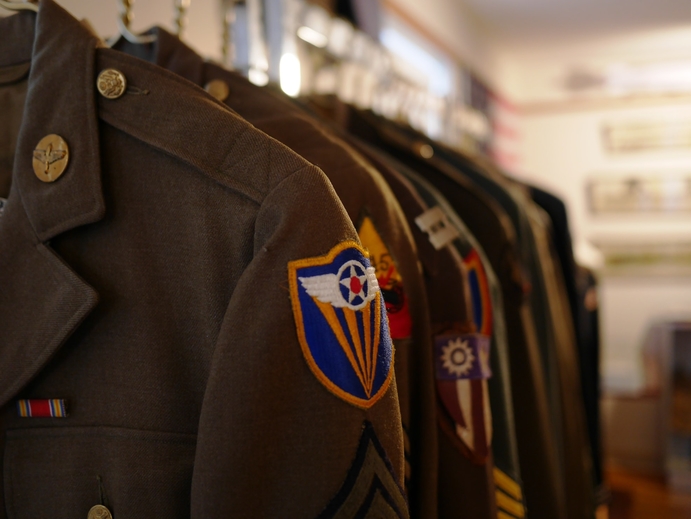 Old military uniforms hanging on a rack