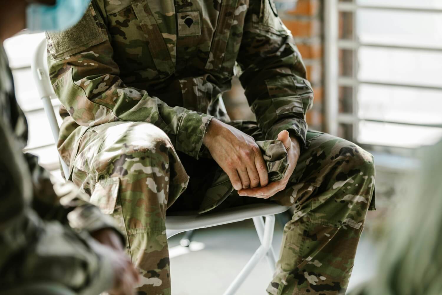 person in chair wearing combat uniform