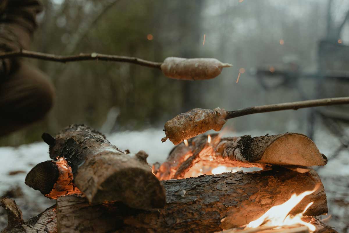 roasting meat over fire on father-son outing